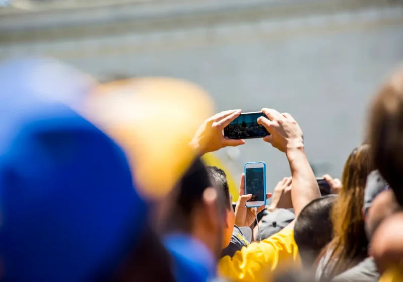 Crowd of fans photographing sporting event